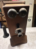 This is an antique wooden wall-mounted crank telephone, likely manufactured by companies such as Kellogg or Western Electric in the early 1900s.