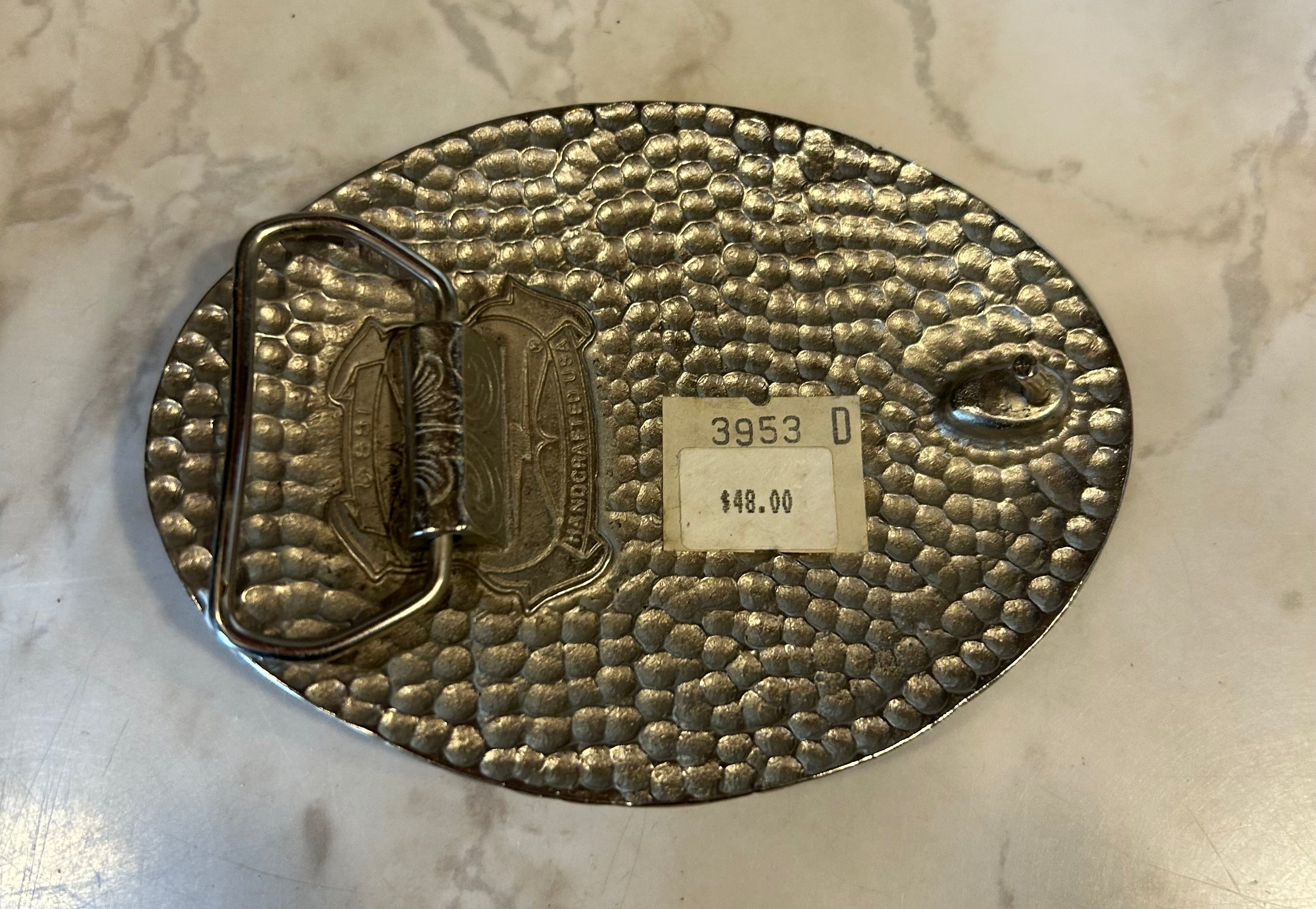 This is a vintage SSI pewter-colored belt buckle featuring a Southwestern or Native American eagle design.