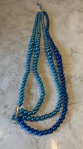 These are multi-strand blue beaded necklaces, featuring a graduated color scheme from light to dark blue.