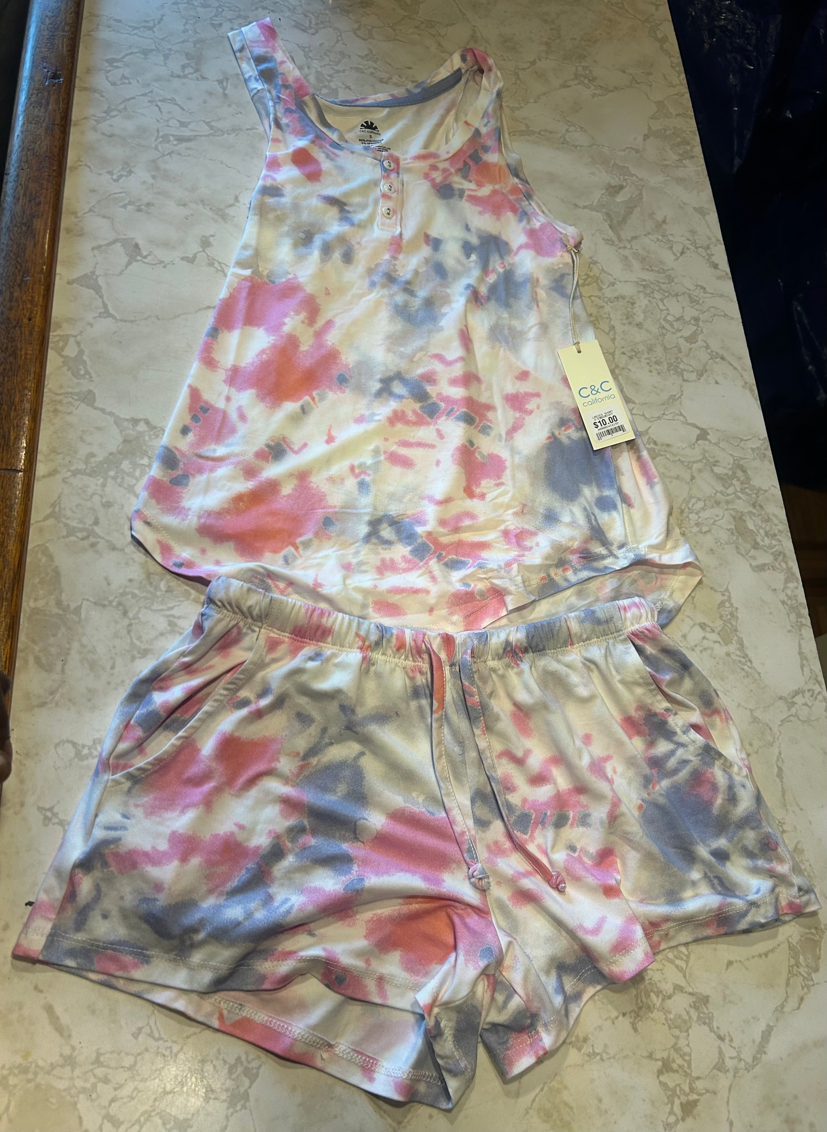 This C&C California tie-dye pajama set features a pink, white, and blue watercolor tank top with buttons and matching drawstring shorts.