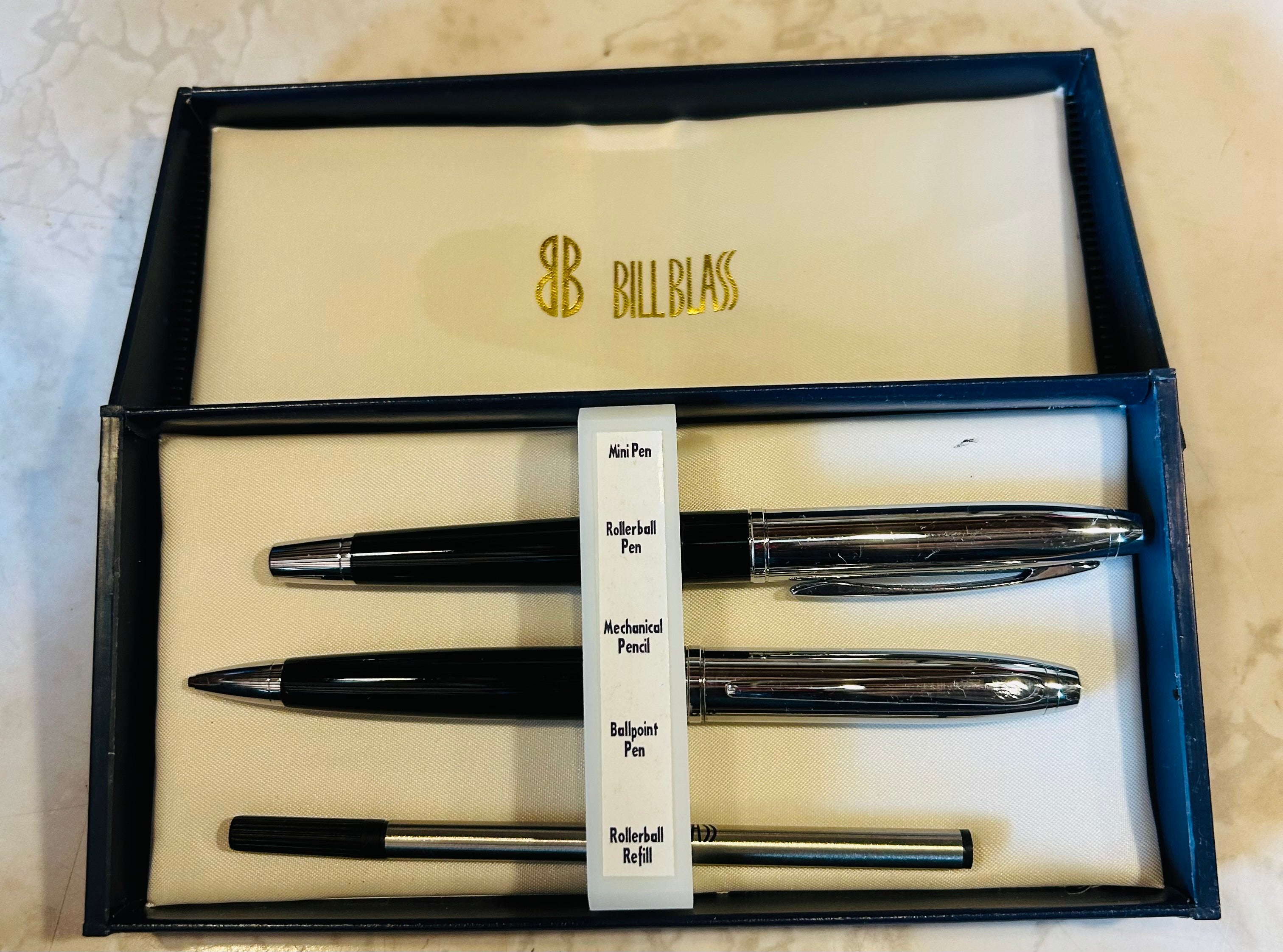 This is a Bill Blass black and chrome pen and pencil set, which includes a ballpoint pen, a rollerball pen, and a mechanical pencil.