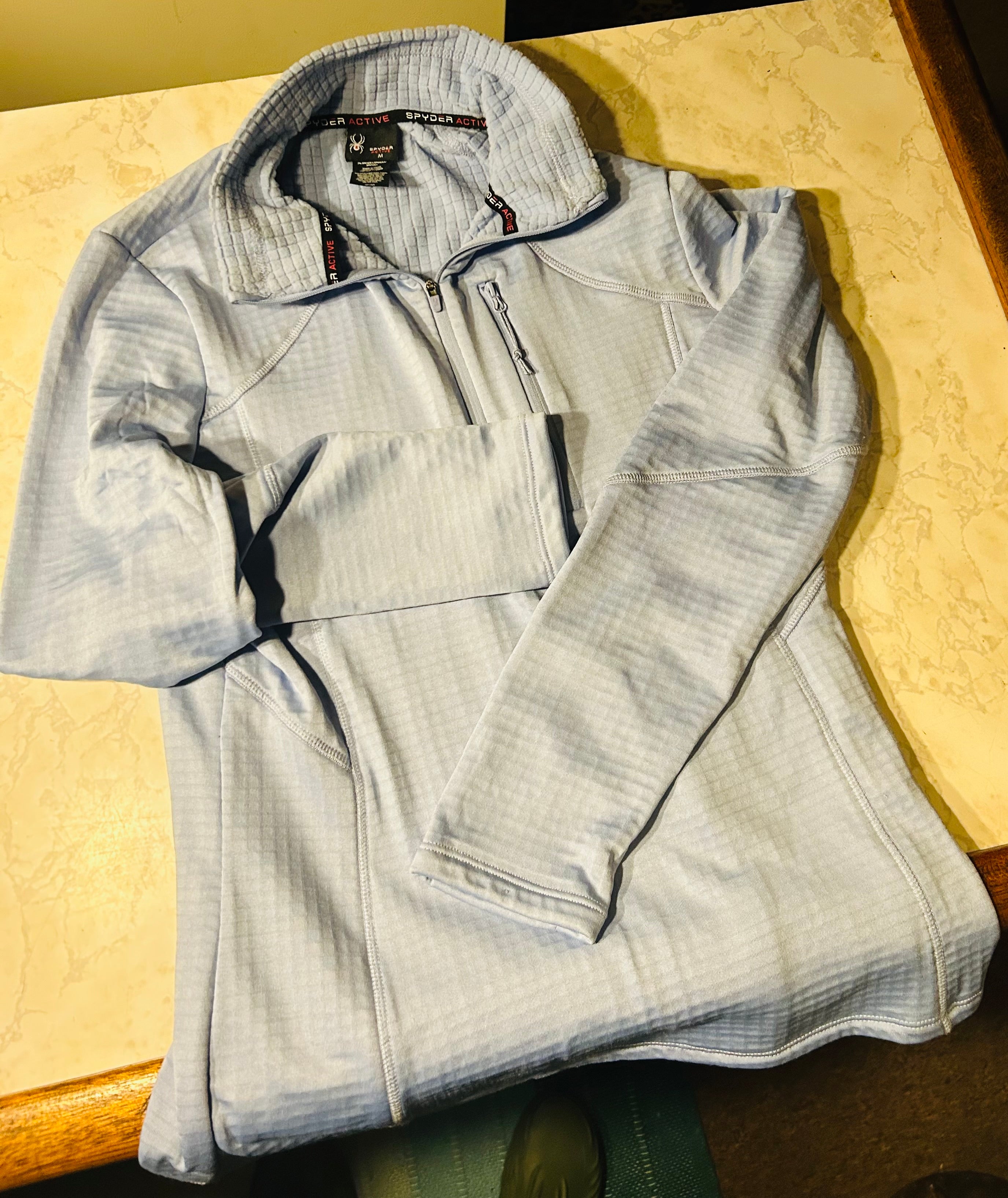 This is a medium light blue Spyder Active women's quarter-zip fleece pullover with a textured grid pattern.