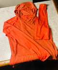 This is a new vibrant orange The North Face FlashDry women's hoodie in size Medium.