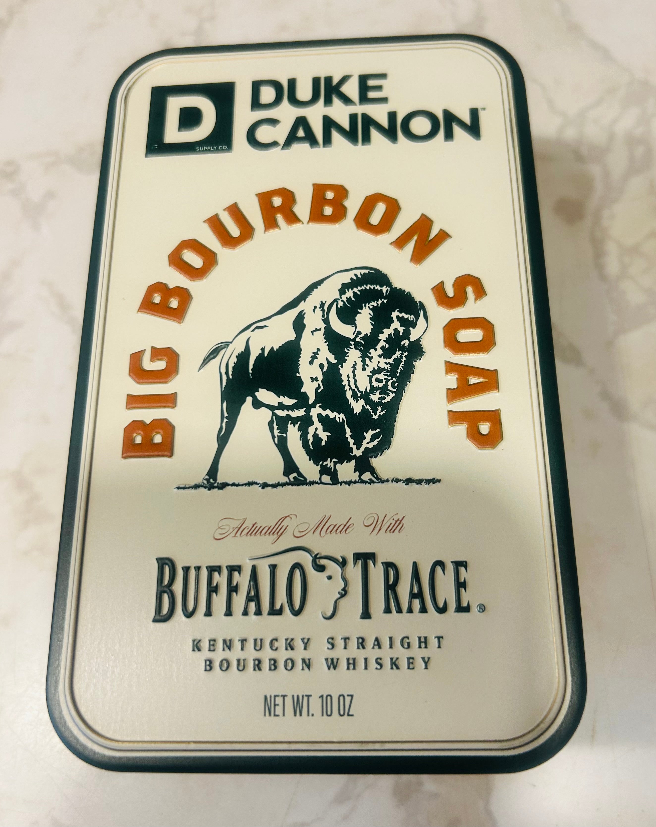 a Duke Cannon Supply Co. Big Bourbon Soap in a collectible tin.