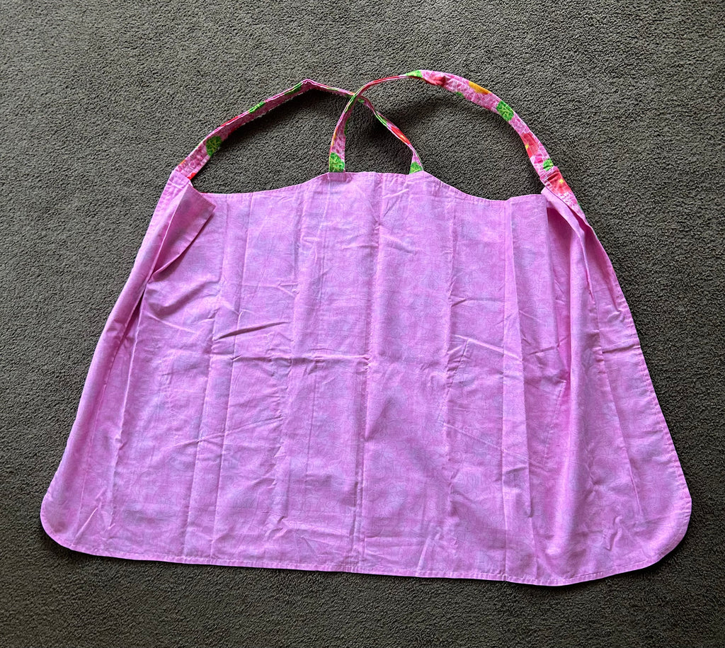 This floral patterned apron features two front pockets and a pink base color.