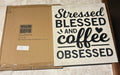 This is a white wall sign with black "Stressed Blessed and Coffee Obsessed" text on nice farm house wood.