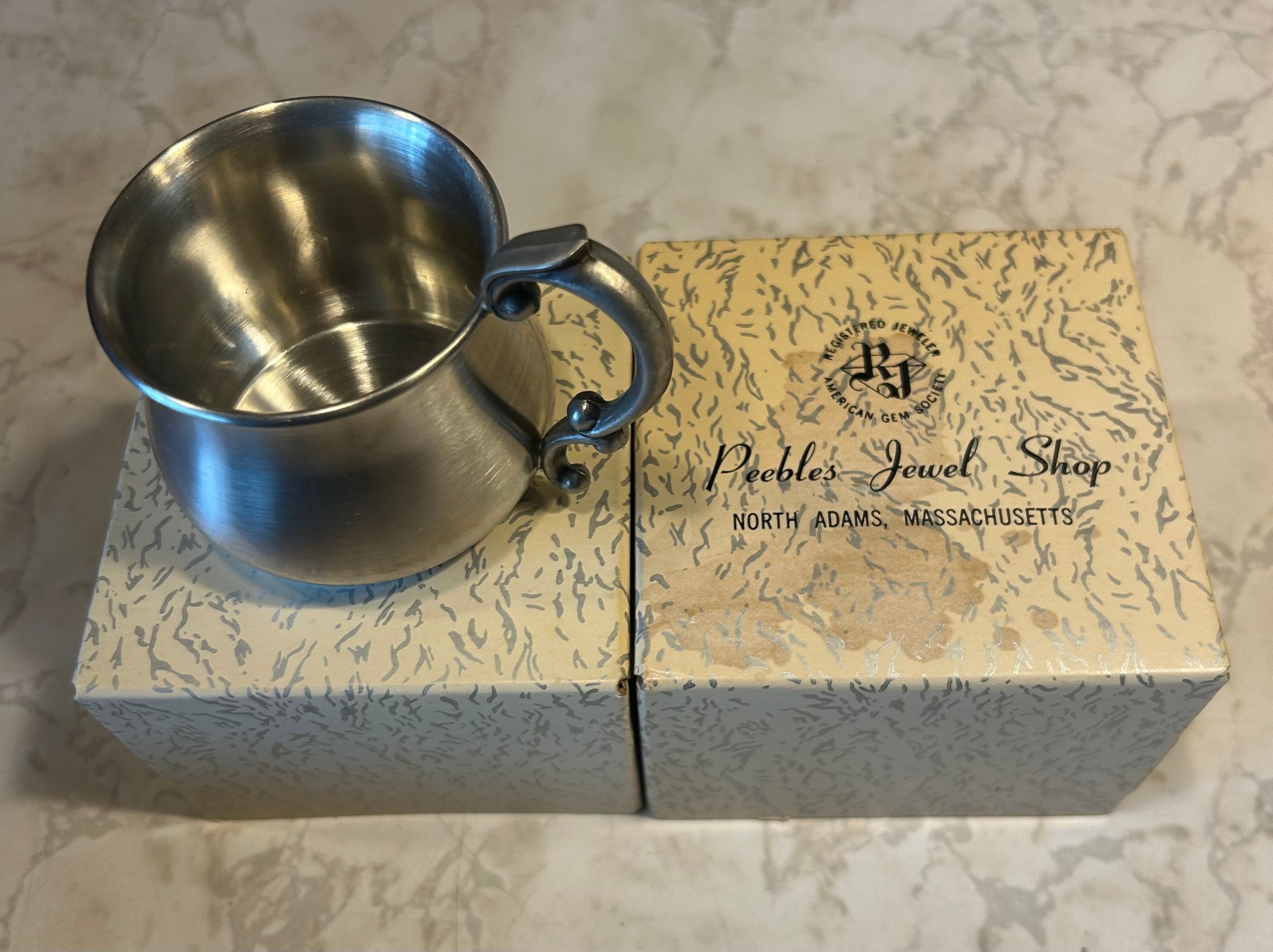 This is a vintage Empire Pewter pot belly baby mug with a polished finish and a stylized handle.