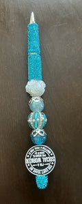 This custom-made, turquoise beaded pen features a social worker slogan and sparkling rhinestone accents.It is designed with a light blue barrel and a beaded top, similar to handmade rhinestone pens sold online.