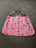 This floral patterned apron features two front pockets and a pink base color.