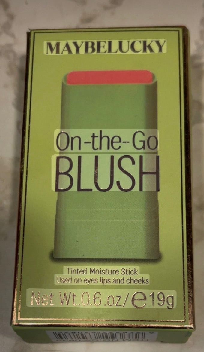 This is a Maybelucky On-the-Go Blush tinted moisture stick in a green and gold package.