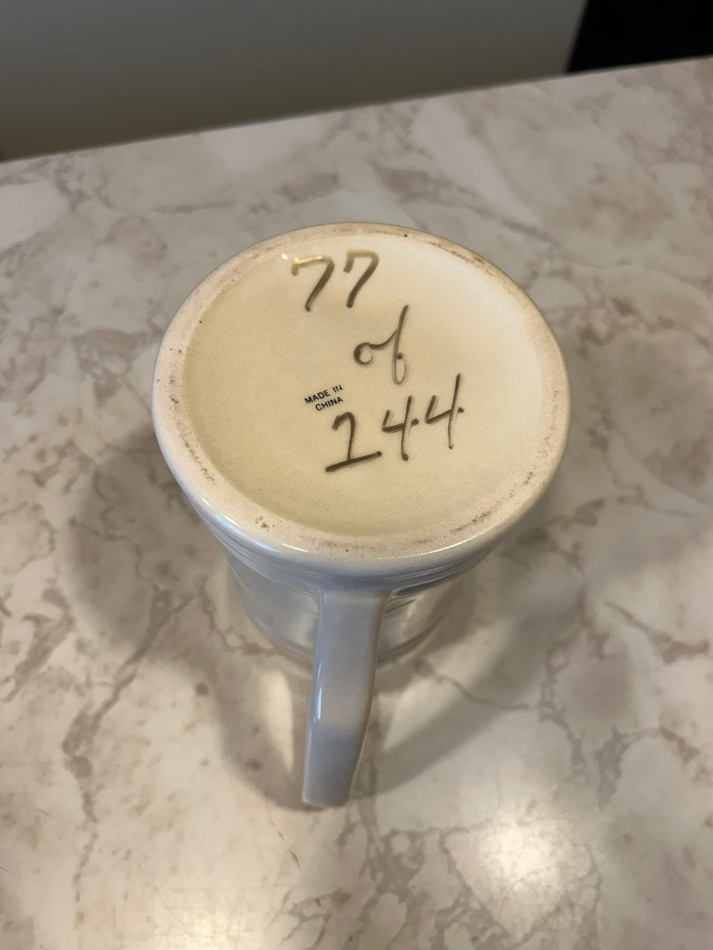 This is a white ceramic beer mug commemorating the 75th Anniversary of an Elk Lodge Veterans Memorial in 1998.