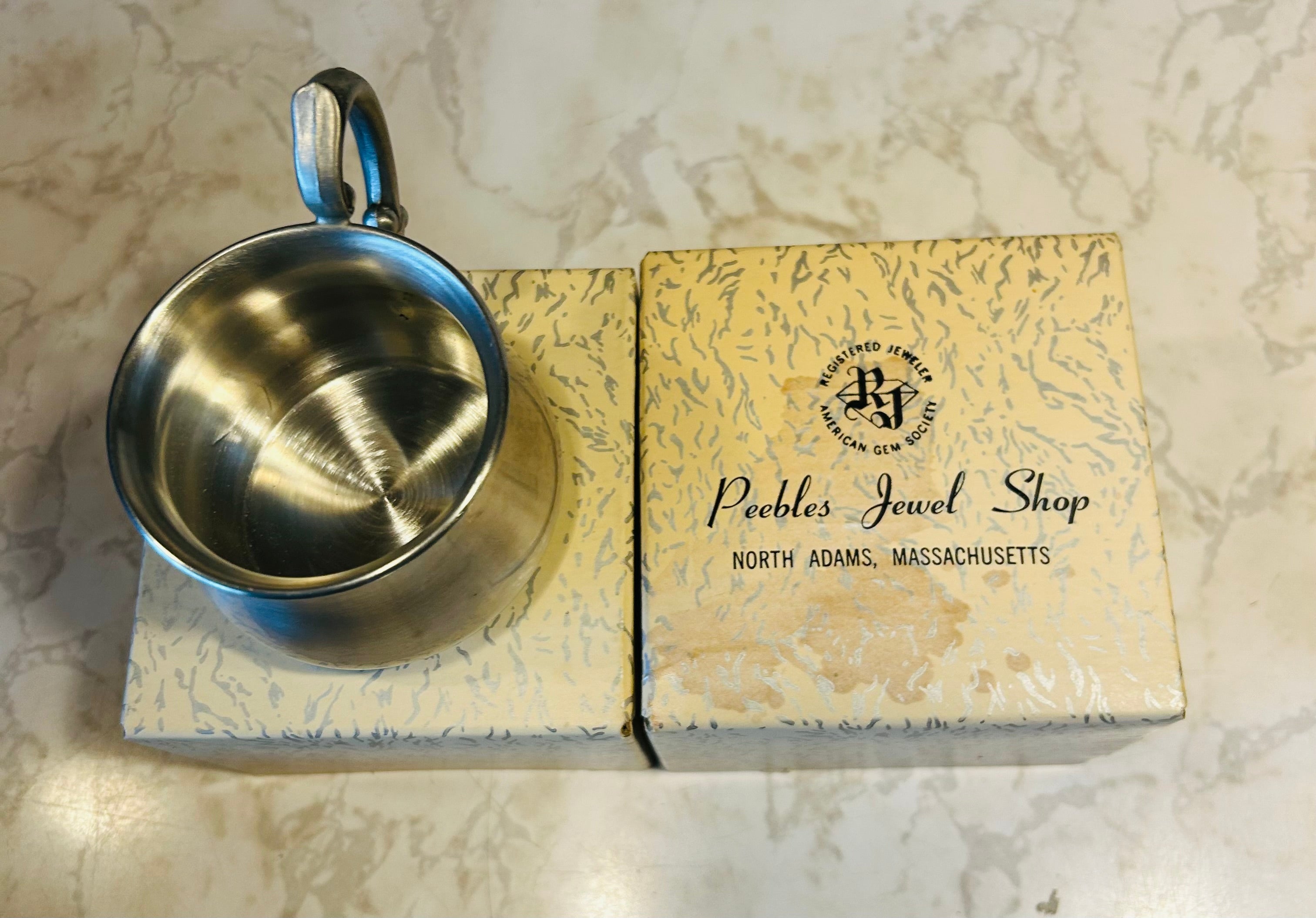 This is a vintage Empire Pewter pot belly baby mug with a polished finish and a stylized handle.