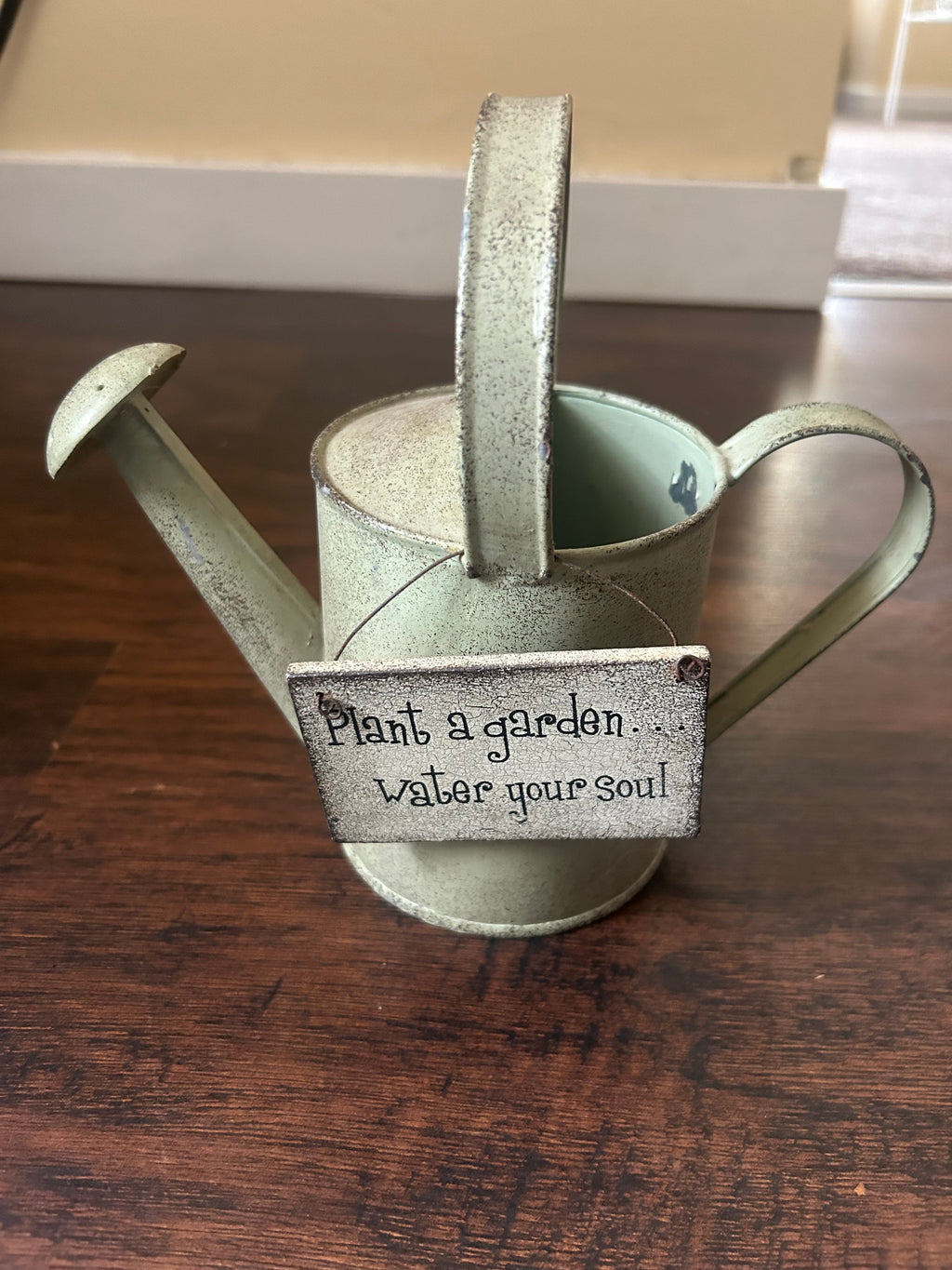 This vintage metal watering can features a rustic farmhouse design with a comforting quote engraved on the front.