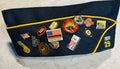 This is a blue American Legion veteran overseas cap adorned with various commemorative pins.